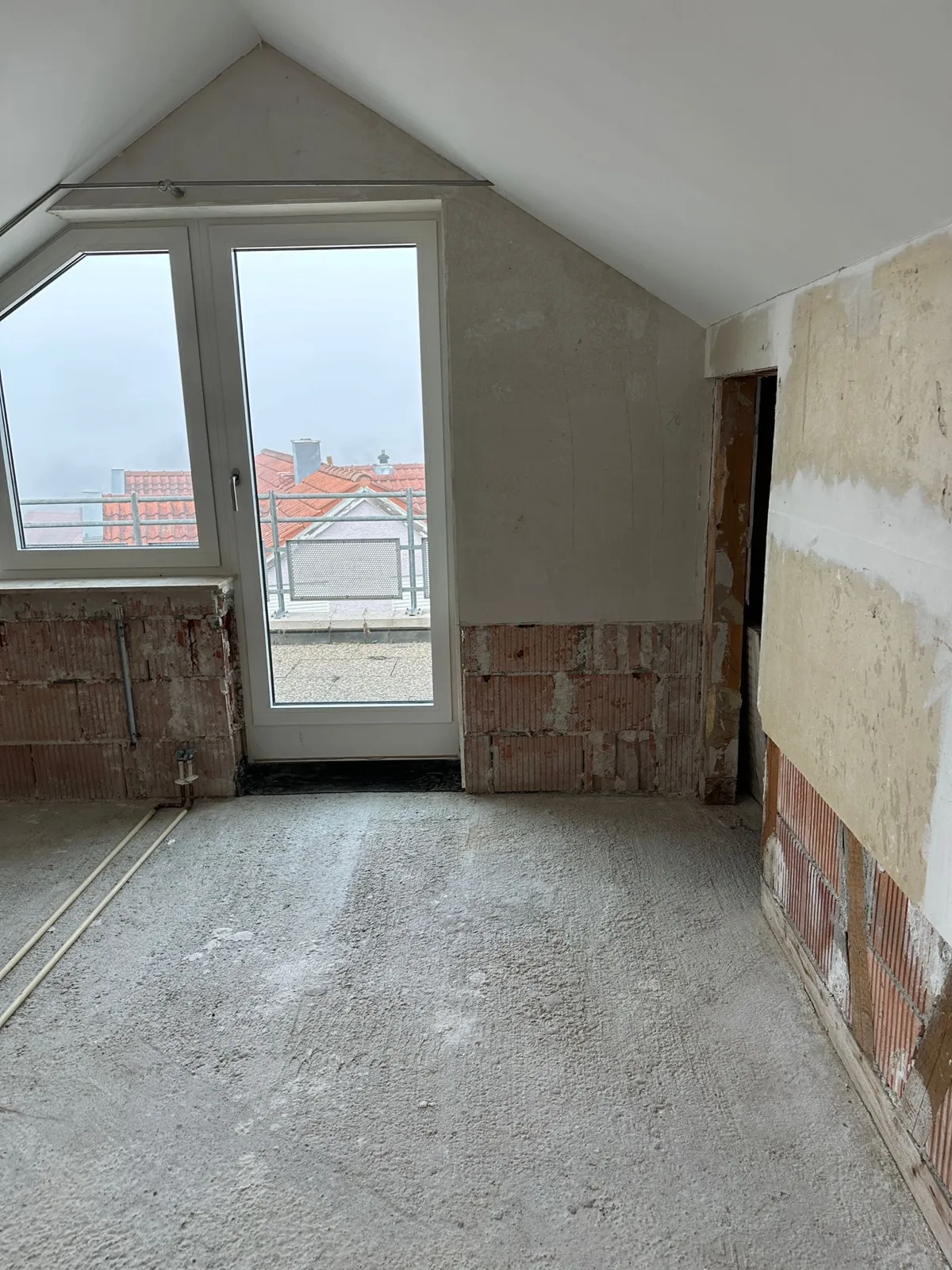 Entkernter Wohnraum mit freigelegtem Mauerwerk und entferntem Estrich nach dem Wasserschaden