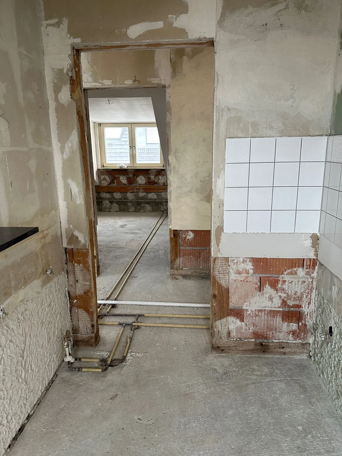Freigelegter Estrich mit neu verlegten Wasserleitungen während des Rückbaus