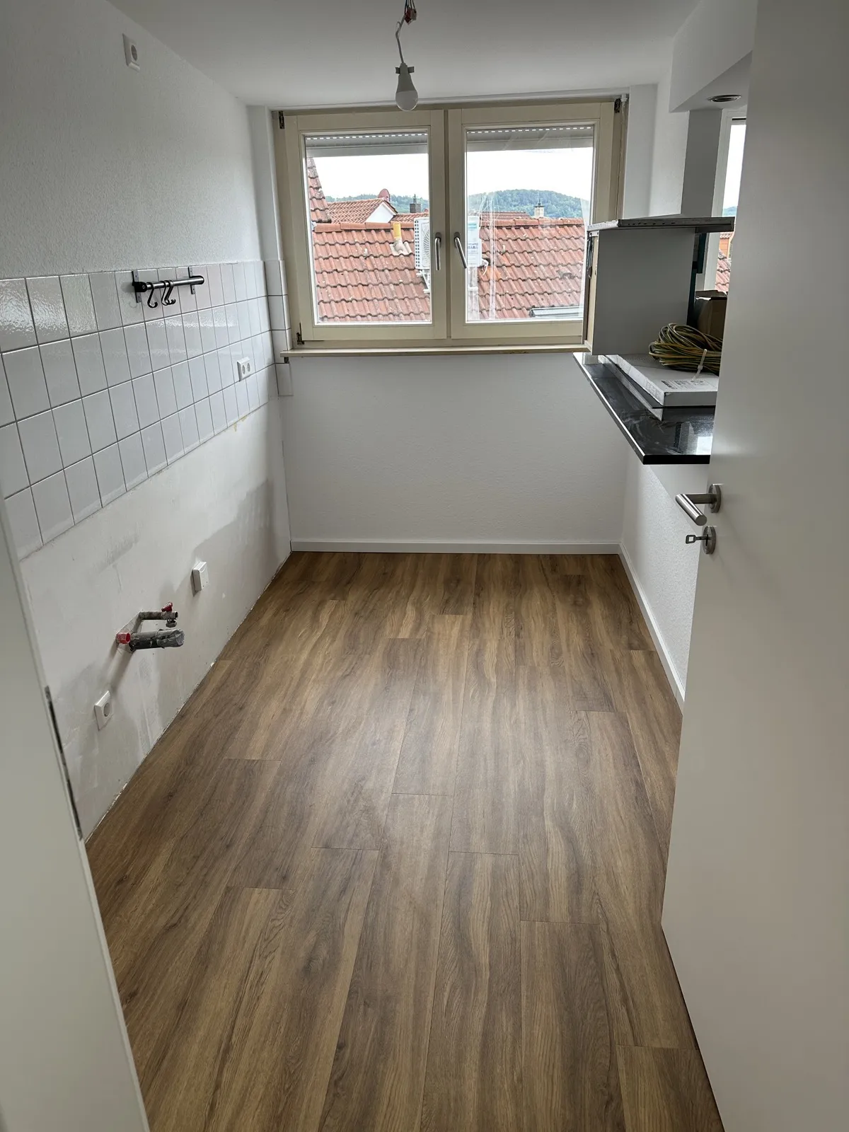 Neue Küche mit hochwertigem Vinylboden und weißem Fliesenspiegel nach Sanierung