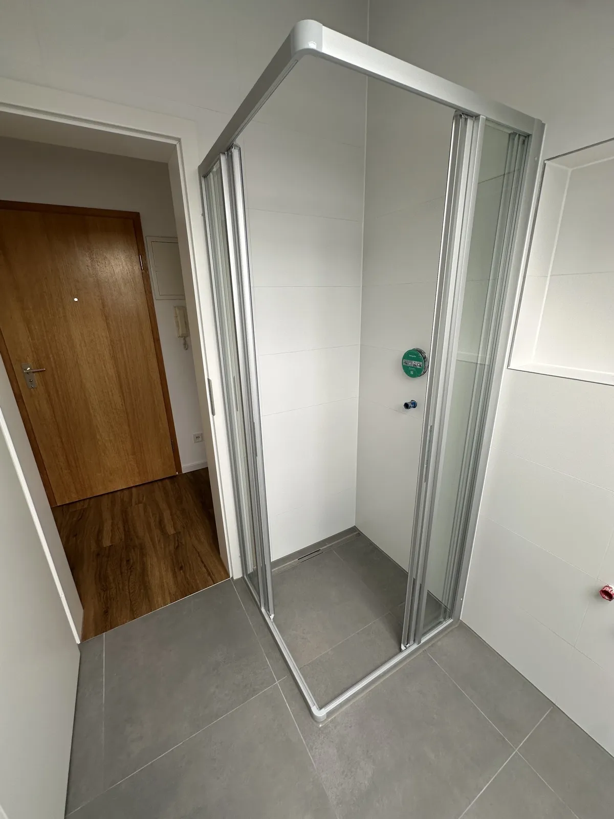 Neue bodengleiche Dusche mit Glasabtrennung im sanierten Bad