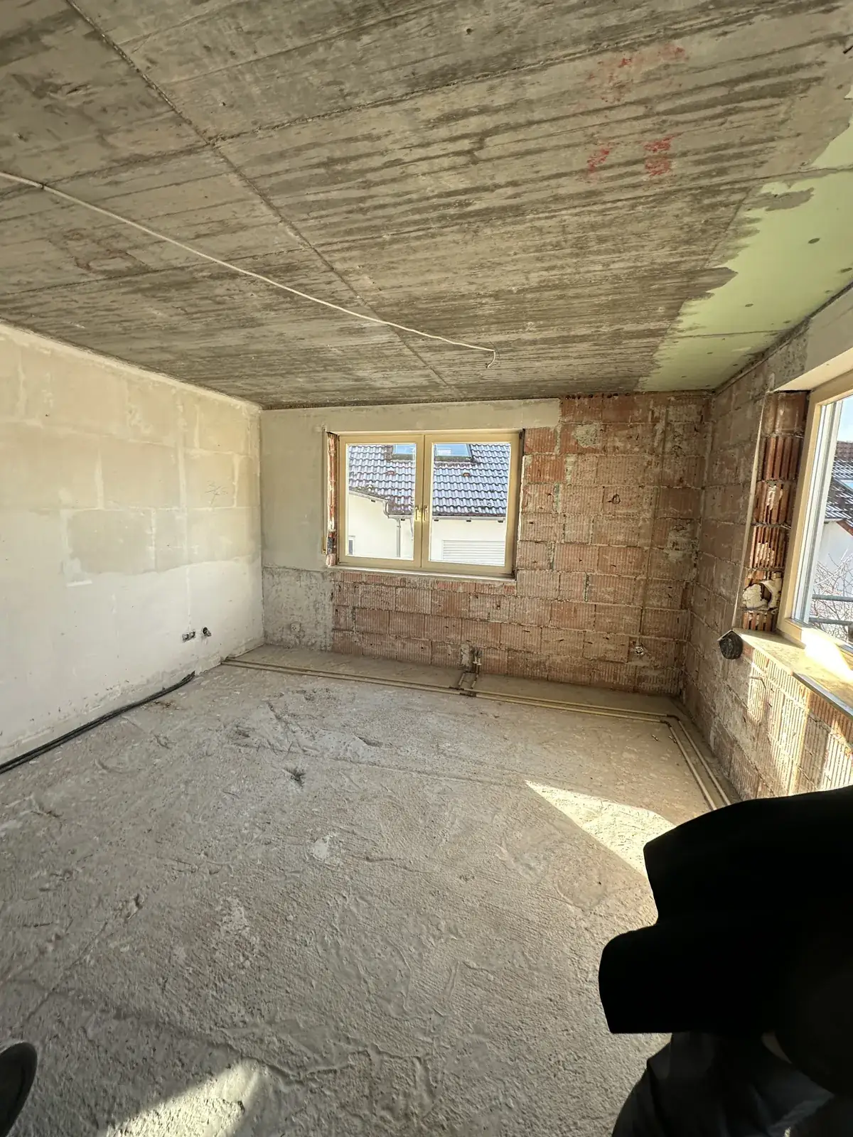 Wohnzimmer im Rohzustand mit abgeschlagenem Putz und freigelegtem Mauerwerk