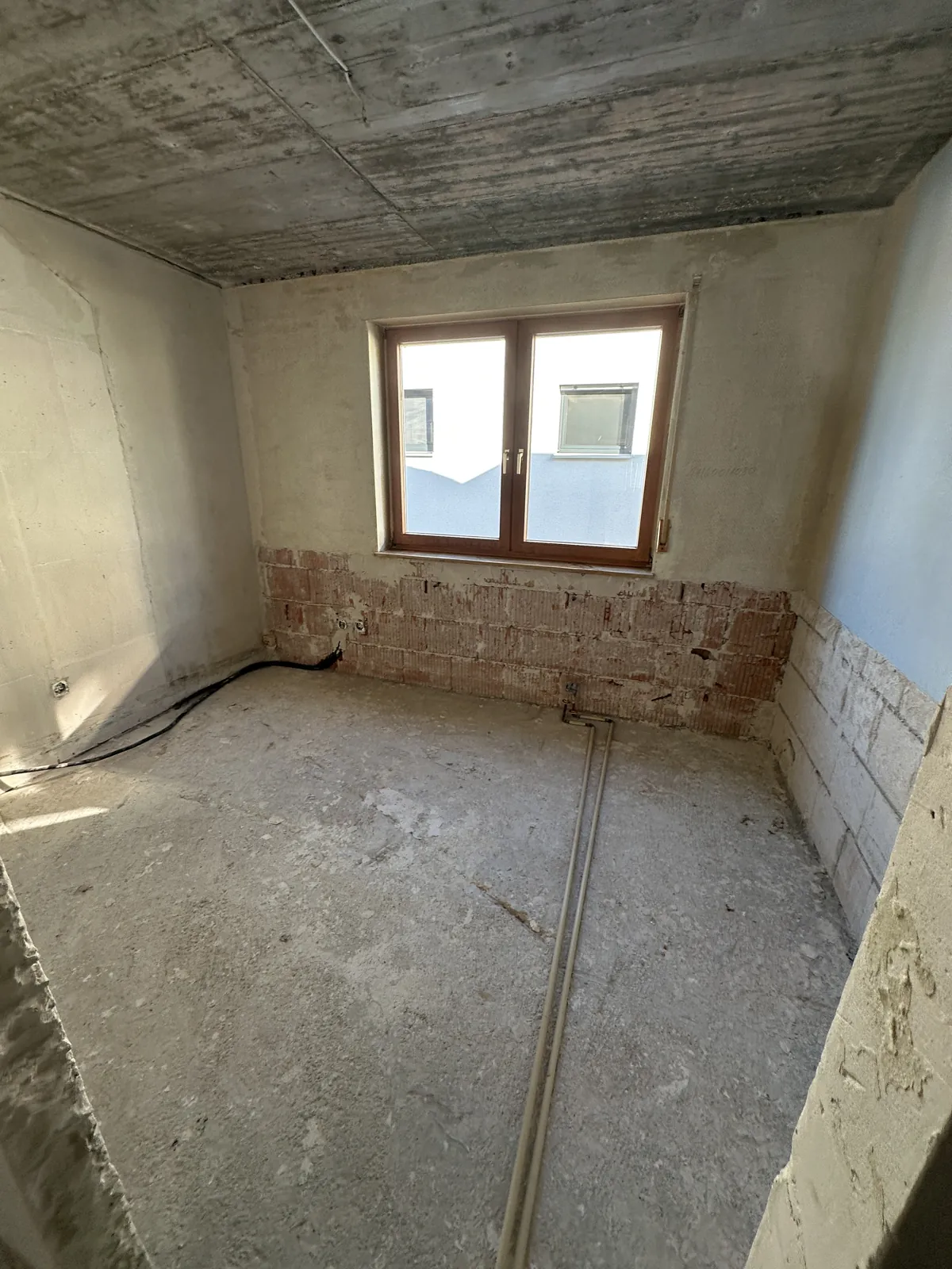 Entkerntes Schlafzimmer mit abgeschlagenem Putz und Rohboden nach dem Wasserschaden