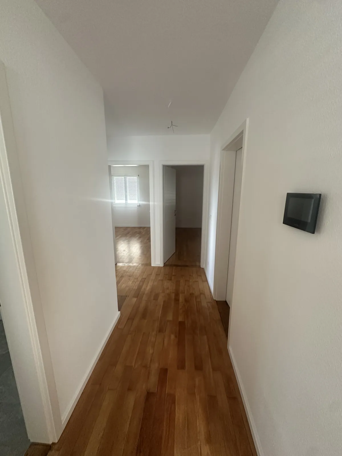 Sanierter Flur mit aufgearbeitetem Parkett und Video-Türsprechanlage
