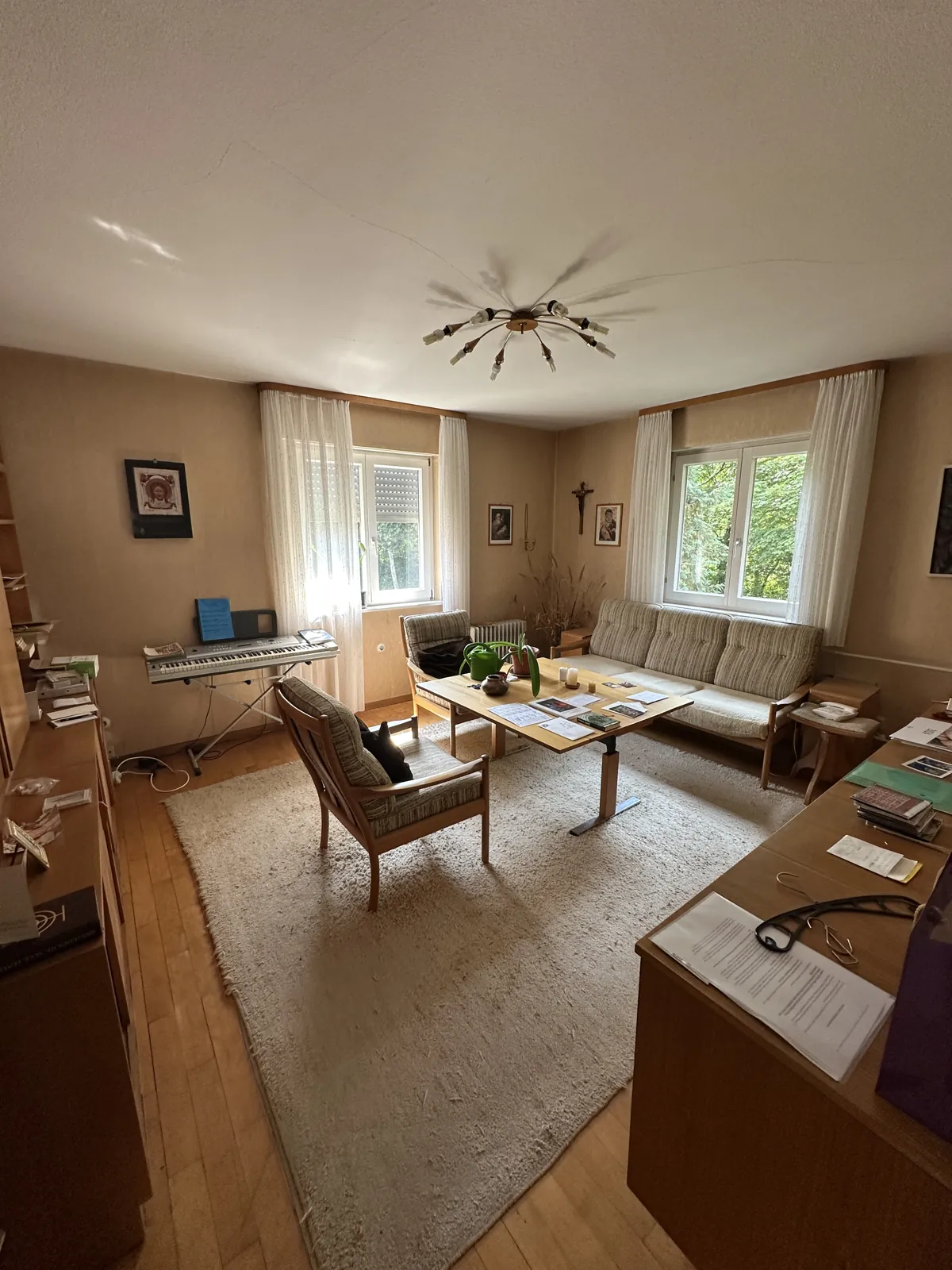 Bewohntes Wohnzimmer mit altem Parkett und Möbeln vor der Kernsanierung