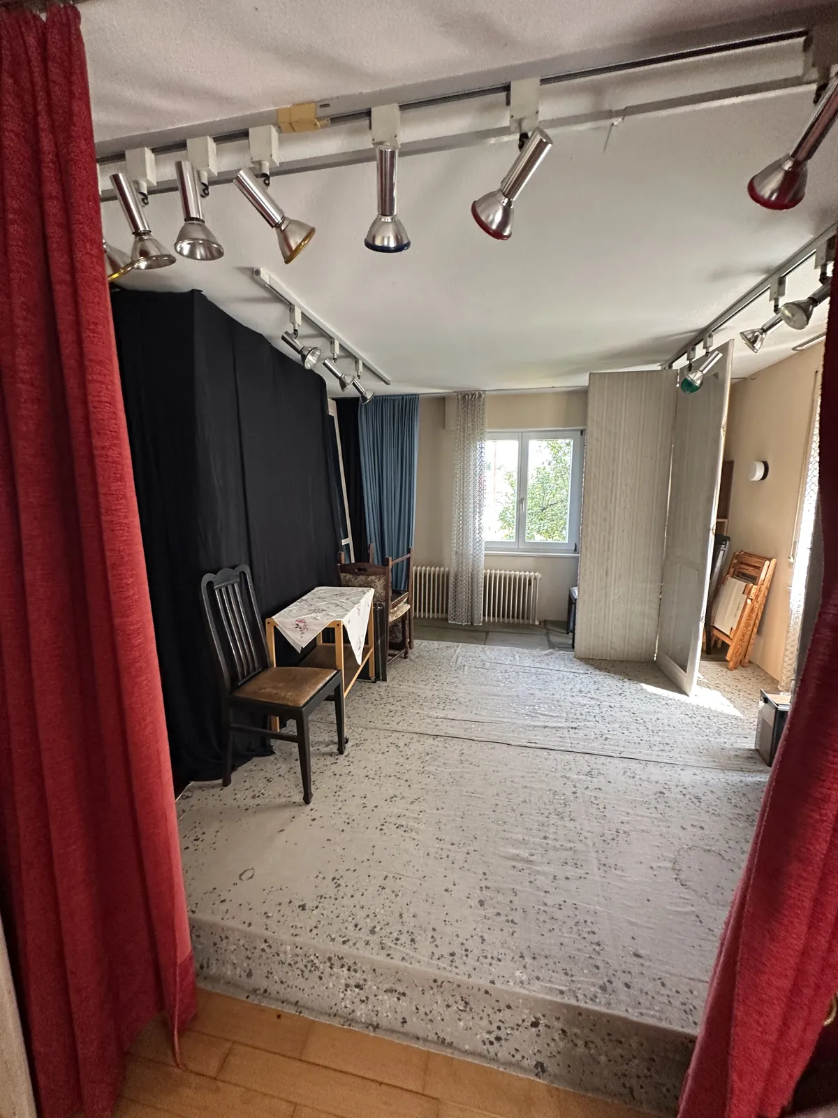 Zimmer mit roten Vorhängen und alter Strahlerleiste im Ausgangszustand