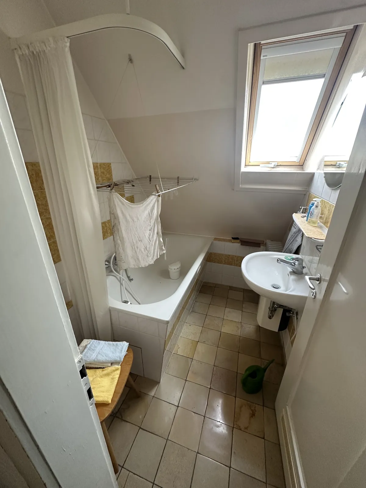 Altes Bad im Dachgeschoss mit Badewanne und Waschbecken unter der Schräge