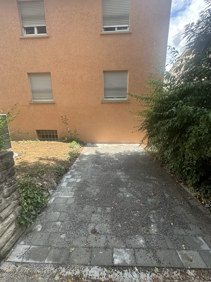 Gepflasterte Zufahrt zum sanierten Dreifamilienhaus nach Abschluss der Arbeiten
